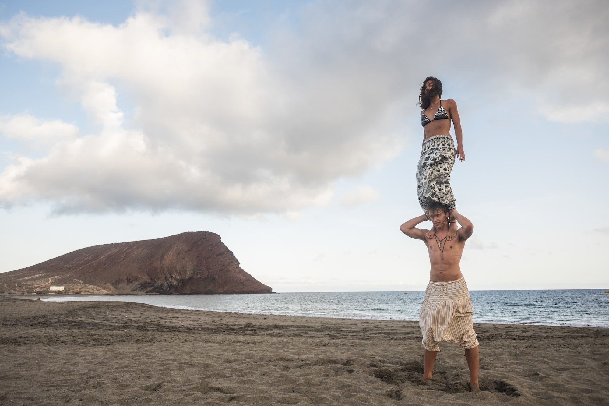 acrobatic balnced position for beautiful brave couple man and woman at the beach